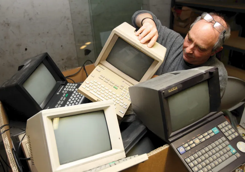 a man in a pile mintels, holding one with his hand.